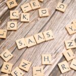 scrabble letters spelling saas on a wooden table