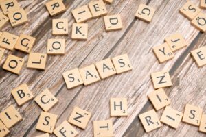 scrabble letters spelling saas on a wooden table